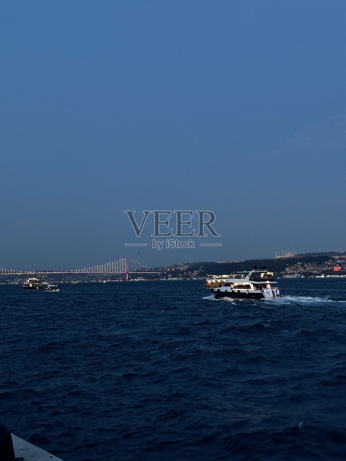 博斯普鲁斯海峡的傍晚船只与城市和桥梁景观照片摄影图片