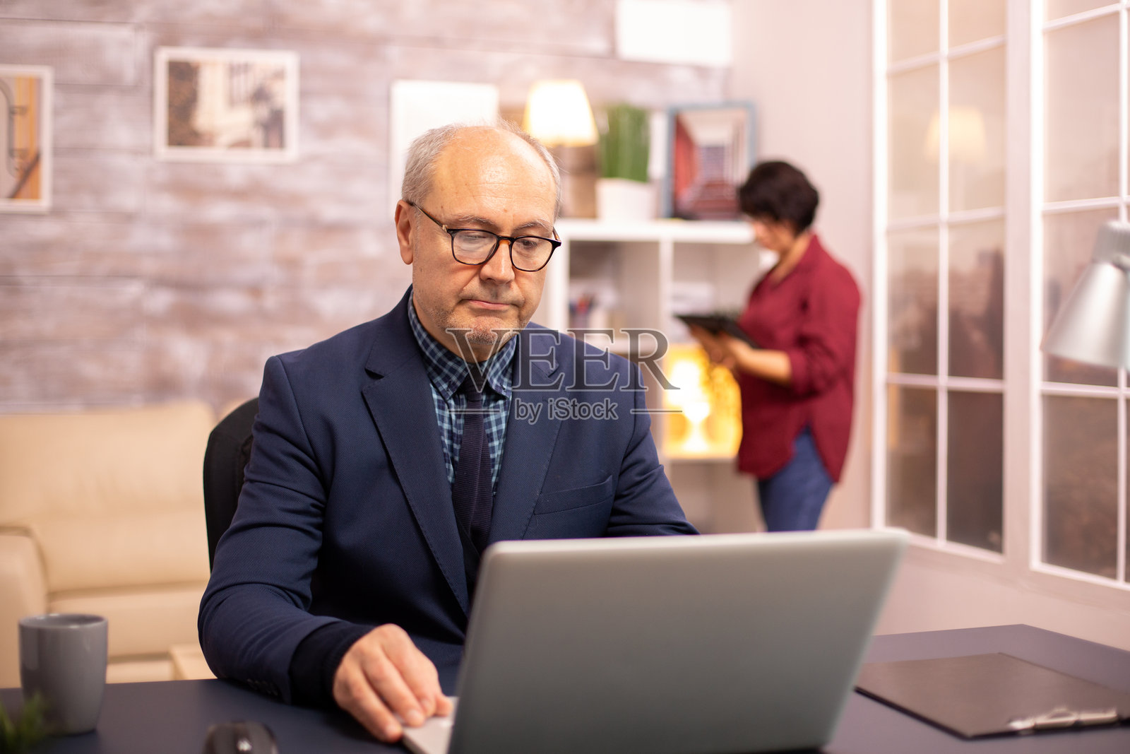 60多岁的老人在舒适的客厅里使用笔记本电脑照片摄影图片