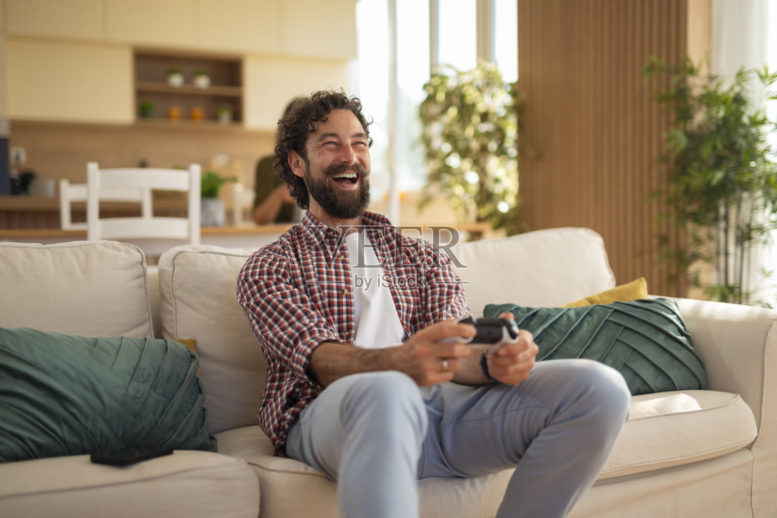 男人在家玩电子游戏时大笑照片摄影图片