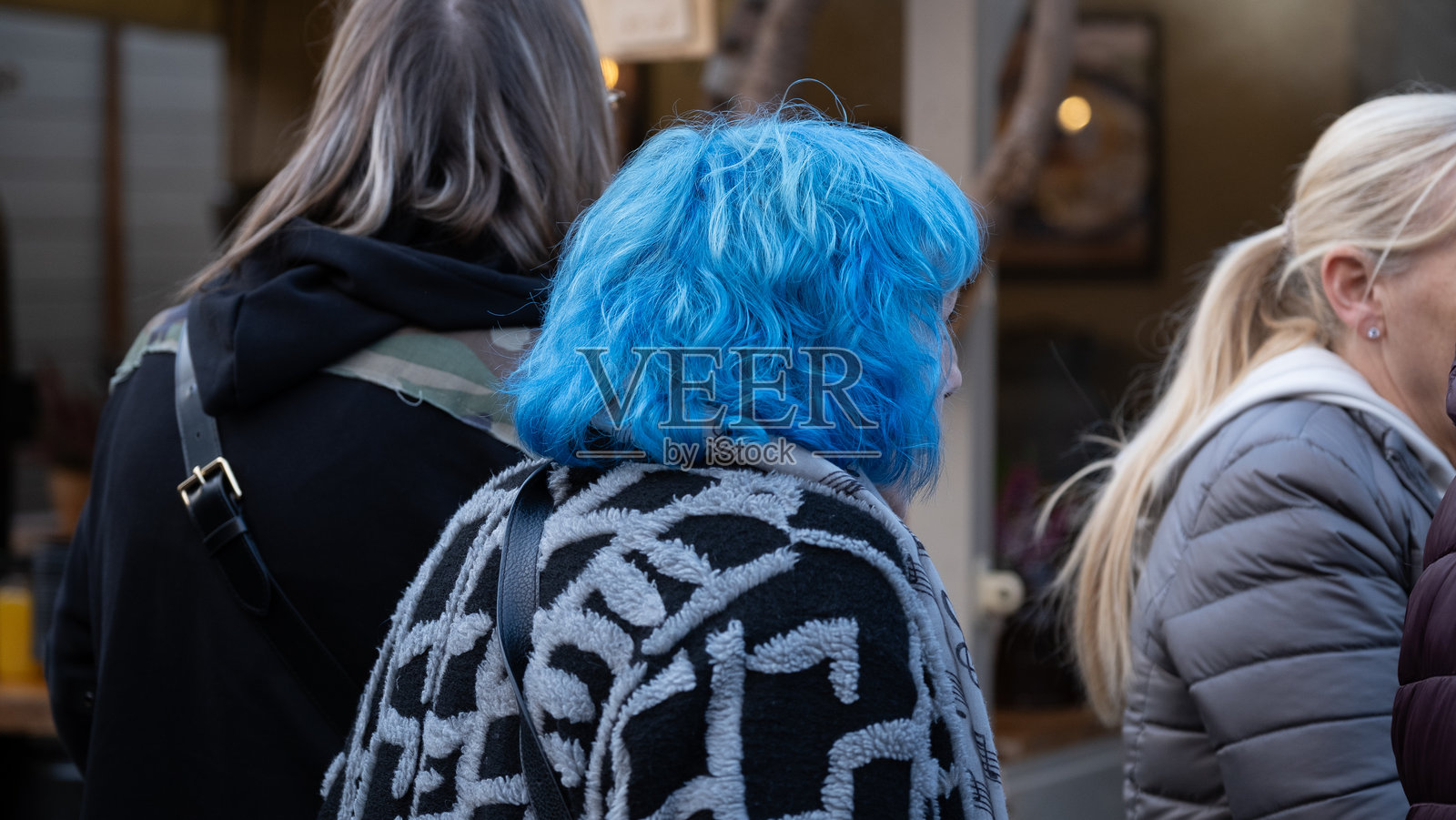 城市街道上的人们，一位女子有着亮蓝色的头发照片摄影图片