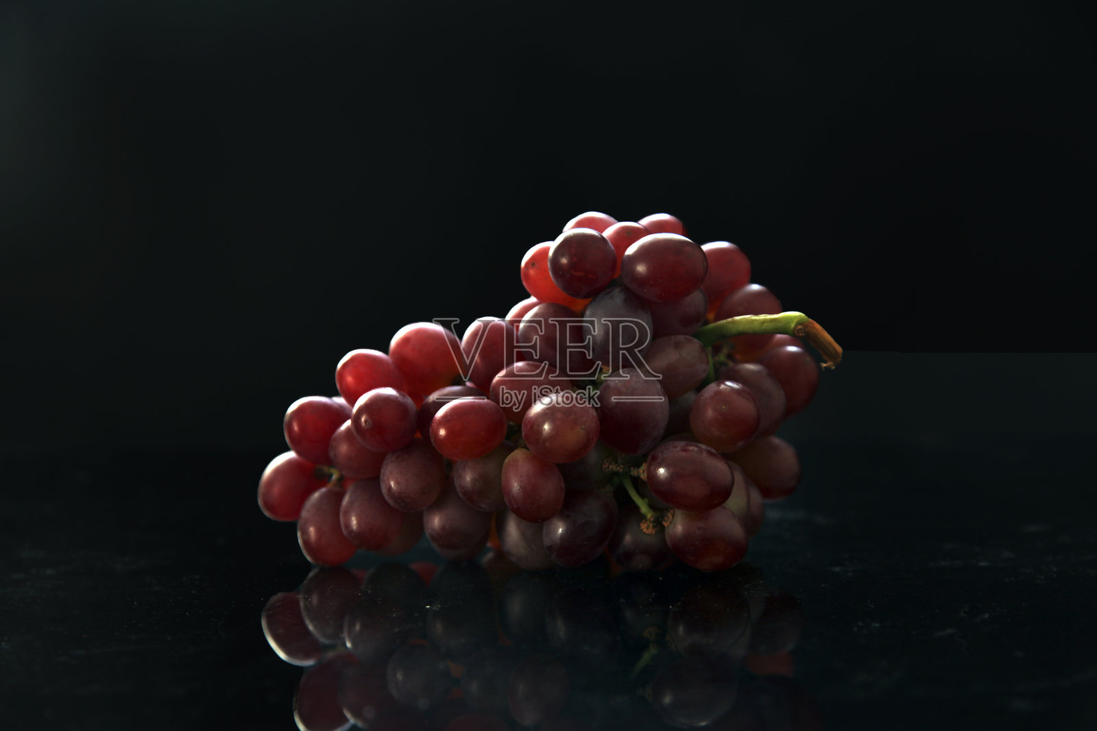 深色背景上的一串新鲜红葡萄照片摄影图片