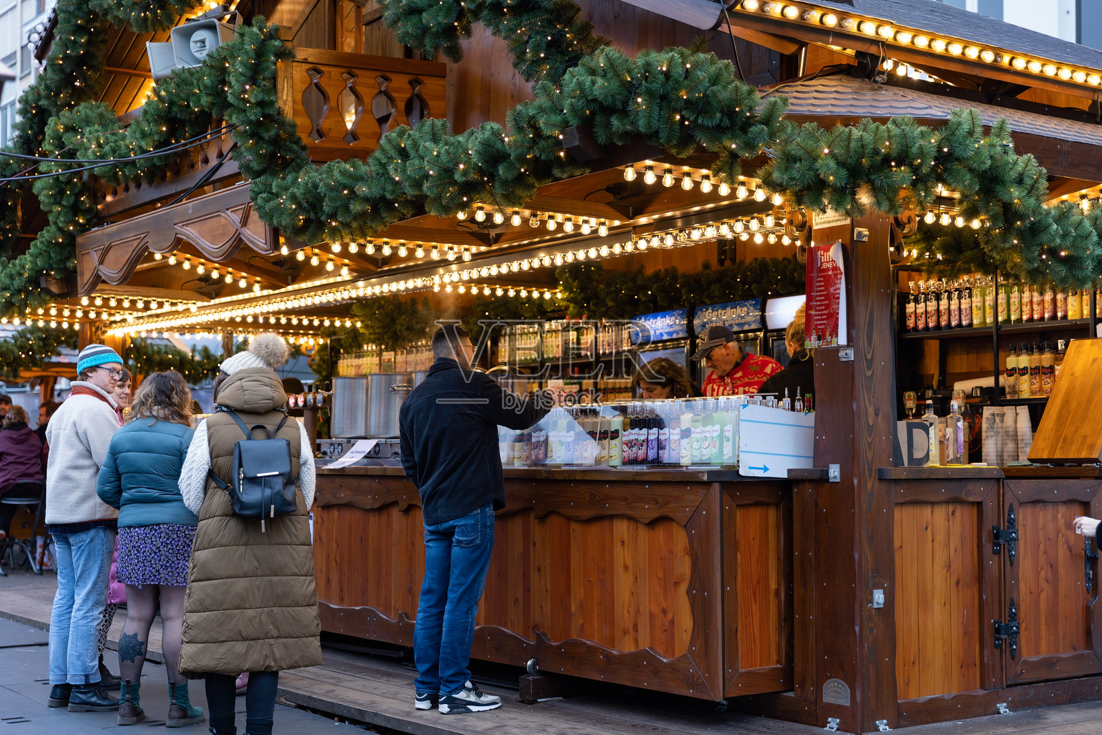 人们在列日圣诞村集市（Noël de Liège）享用美食和饮品照片摄影图片