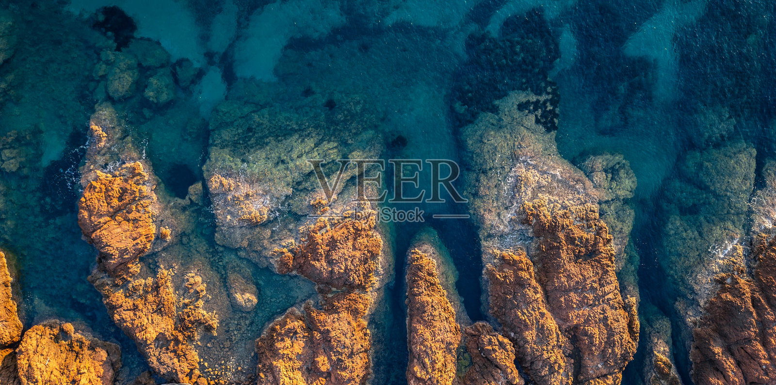 无人机航拍埃斯特雷勒悬崖与岩石，坐落于碧绿的地中海，崎岖的海岸线，清澈的海水，展现出自然的纹理，如电影般的风景视角。照片摄影图片