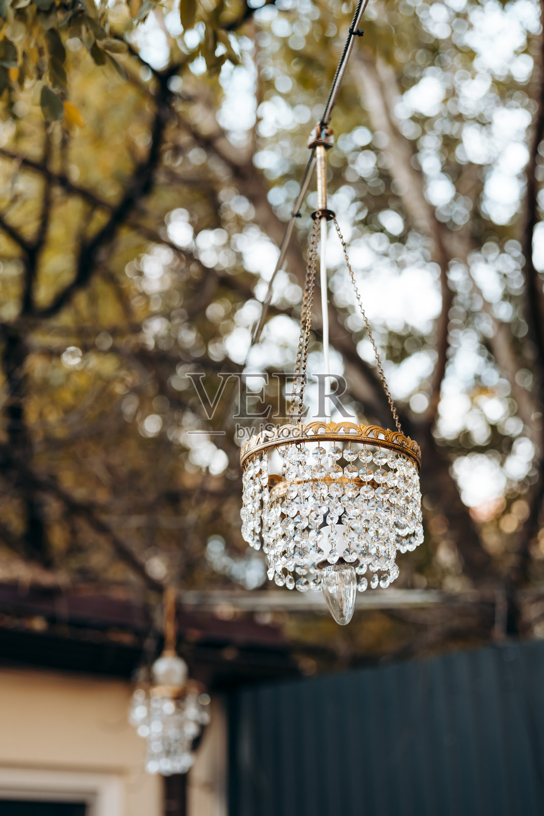 水晶吊灯悬挂在户外，背景是秋天的落叶。照片摄影图片