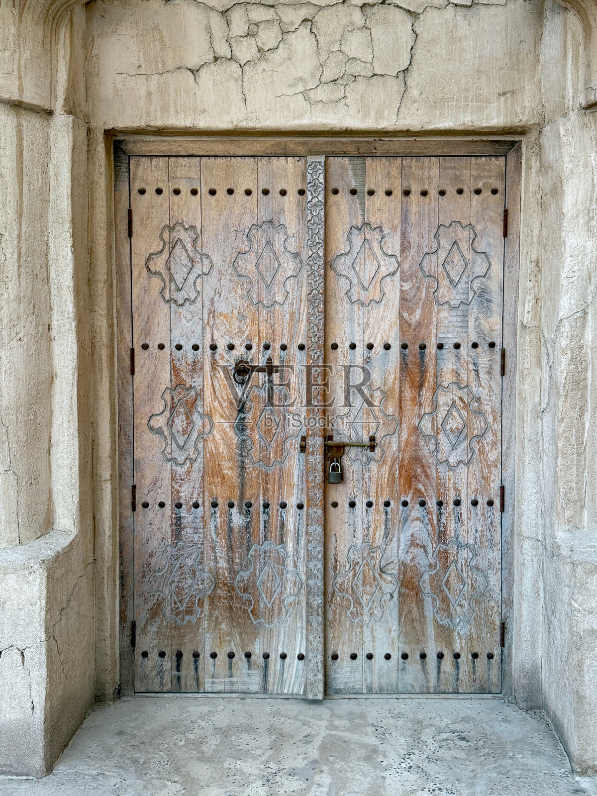 古老的石头墙上饰有华丽的木门，带有传统雕刻和金属锁。历史建筑背景。照片摄影图片