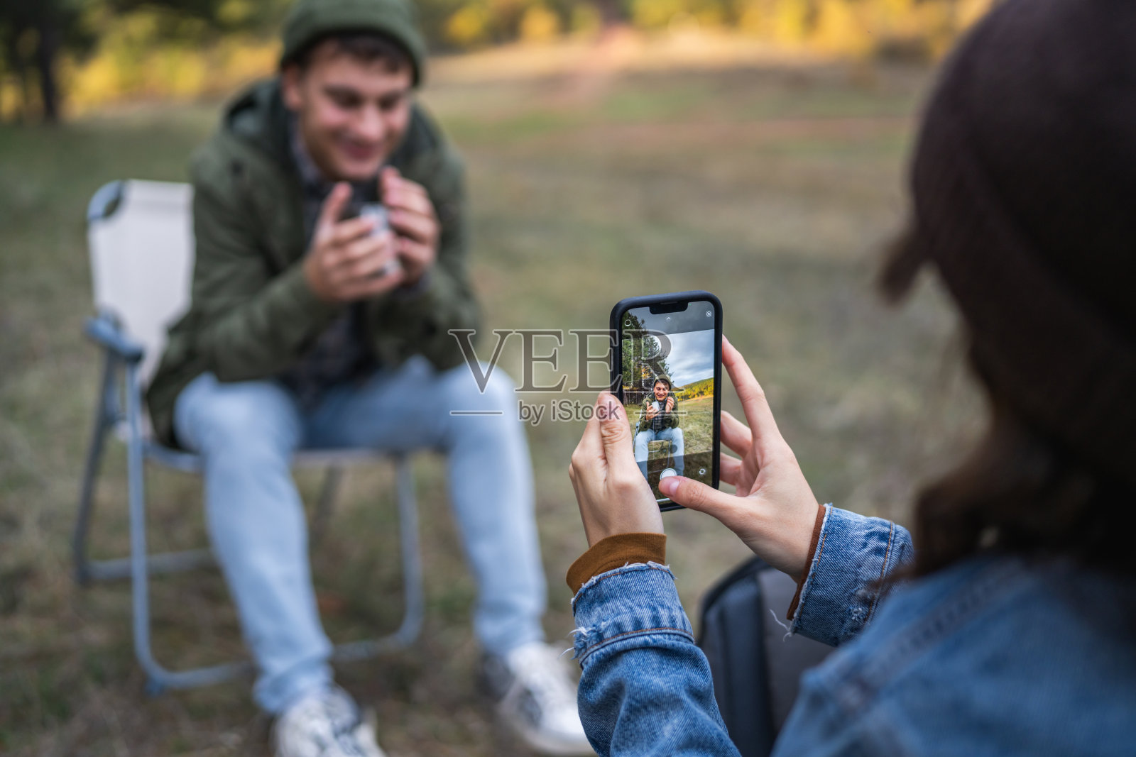 情侣在森林里露营，用智能手机拍照照片摄影图片
