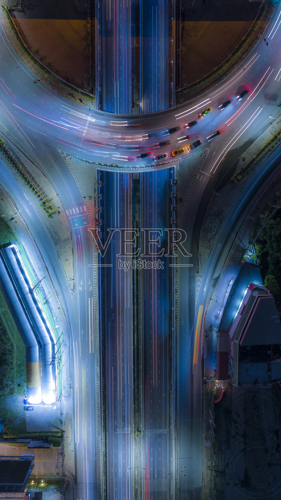 繁忙城市高速公路的惊艳航拍夜景，车辆移动留下的多彩光轨，展现了都市的活力与节奏、现代化的基础设施以及夜幕下的城市律动。照片摄影图片