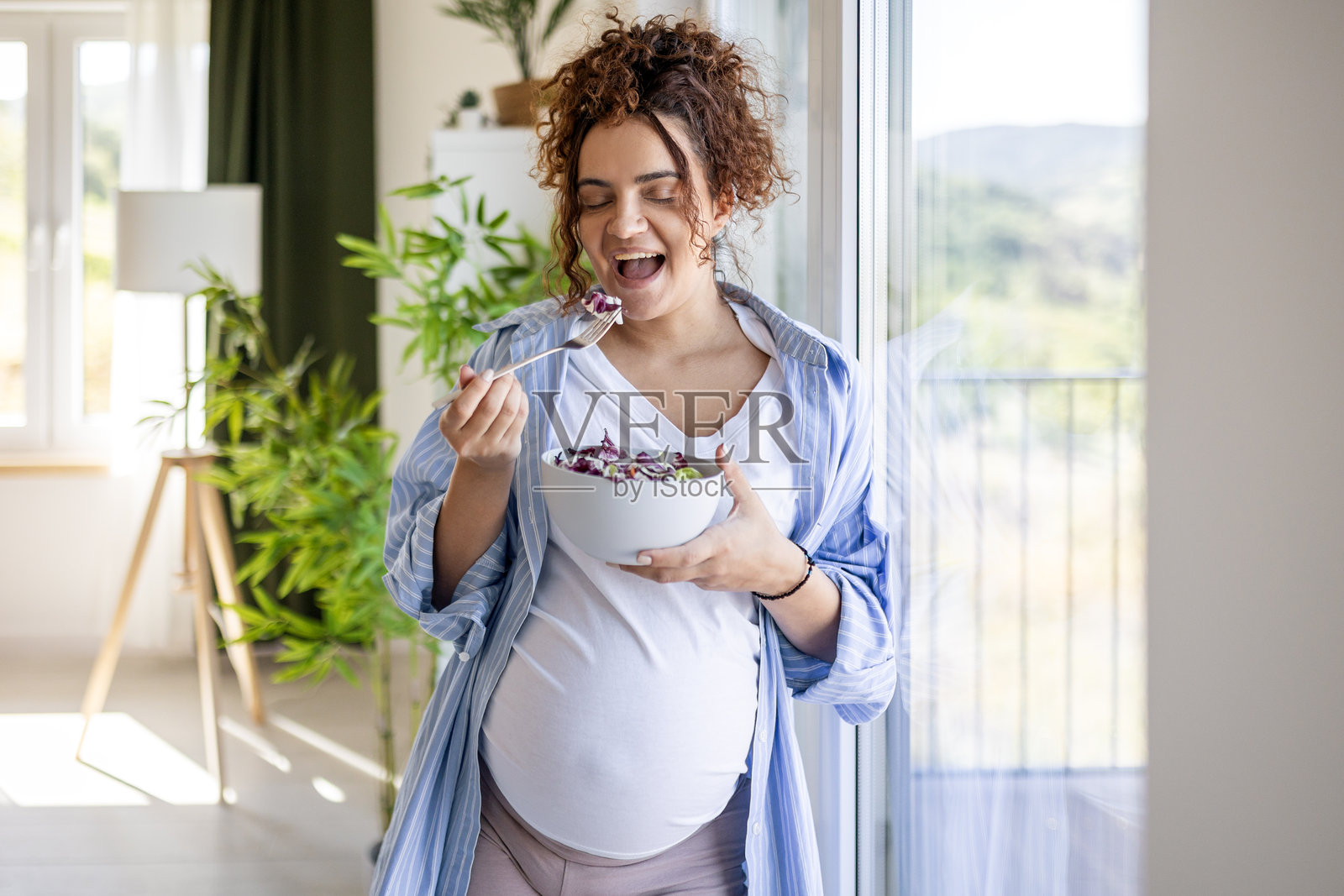 准妈妈在窗边享用营养健康的食物照片摄影图片