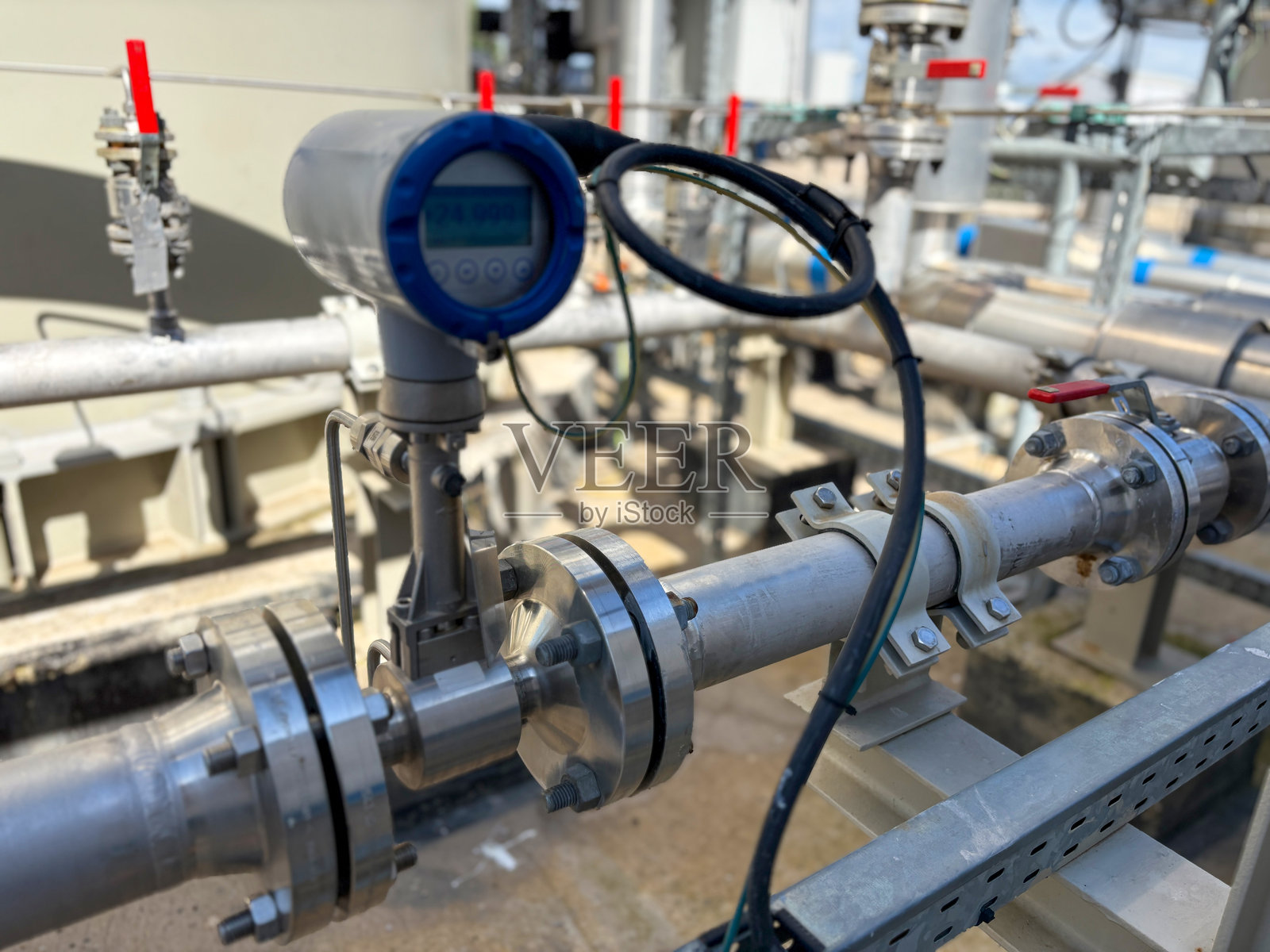 安装在工业管道上的带数字显示的超声波流量计。照片摄影图片