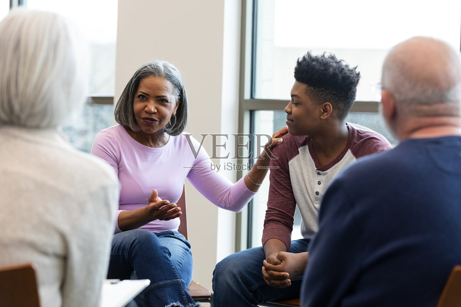 经验丰富的女性在小组会议中为年轻人提供支持和指导。照片摄影图片