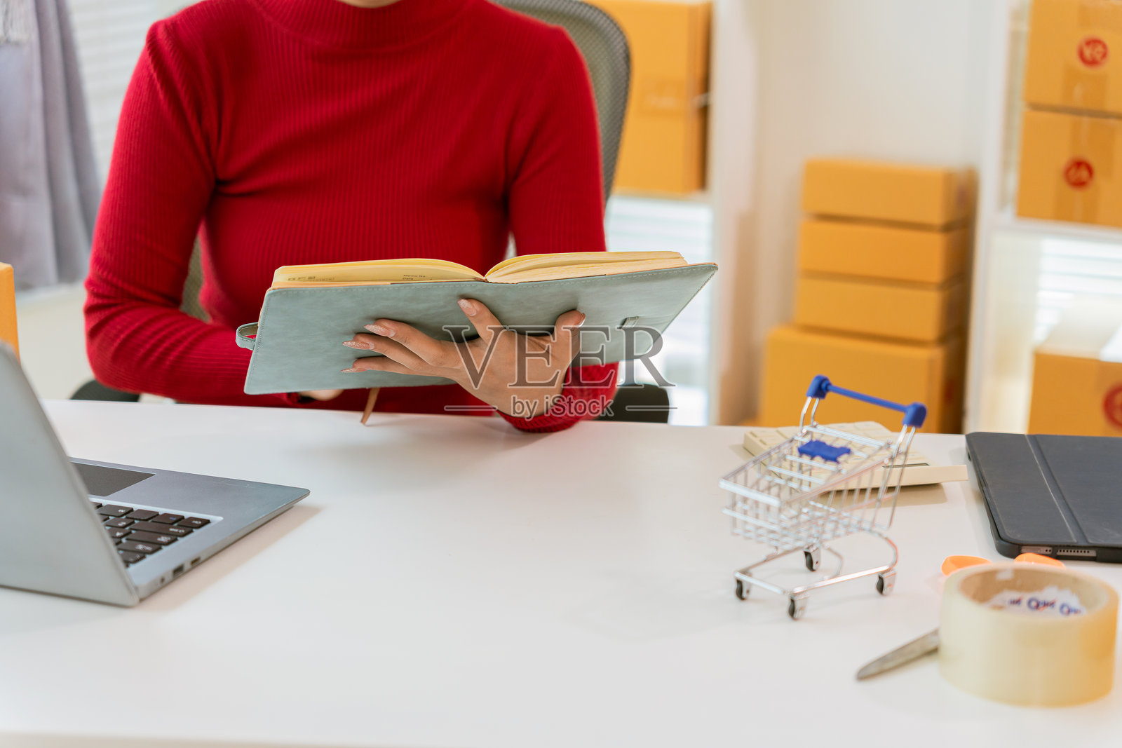 小型企业主在家中使用笔记本电脑进行电子商务、中小企业创业、企业家处理收据盒和在线订单。照片摄影图片