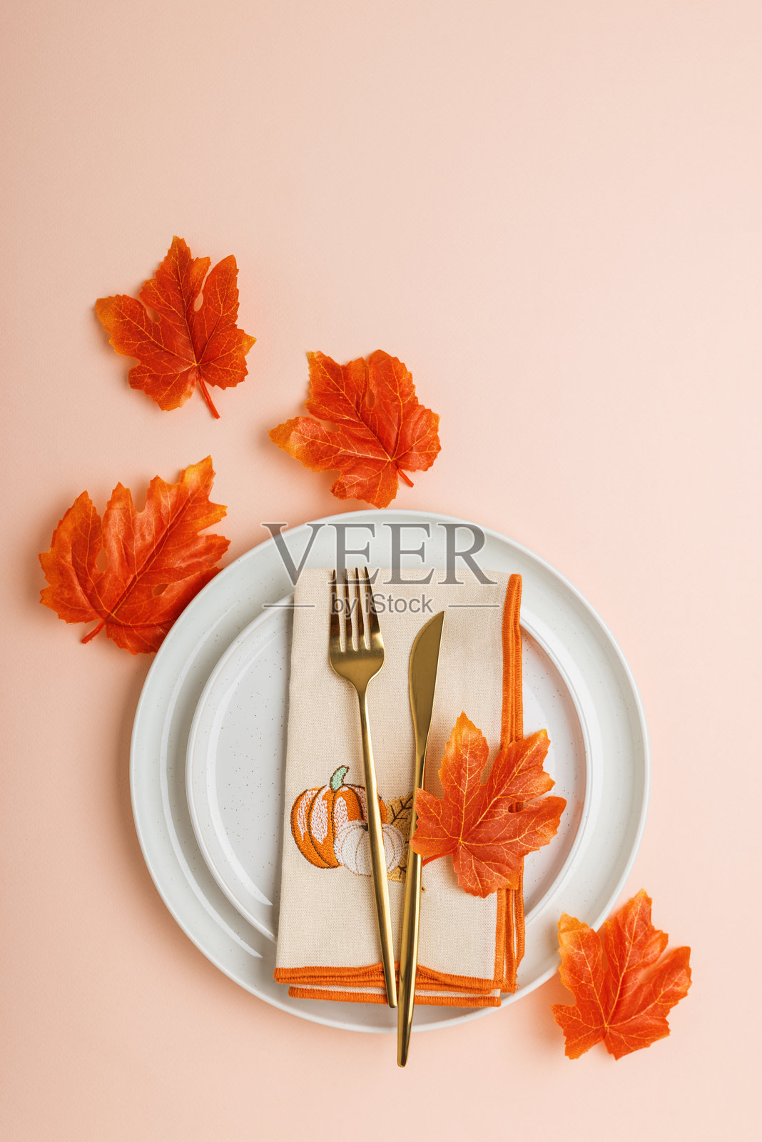 节日秋季餐桌布置，配有餐巾、金色餐具和季节性装饰照片摄影图片