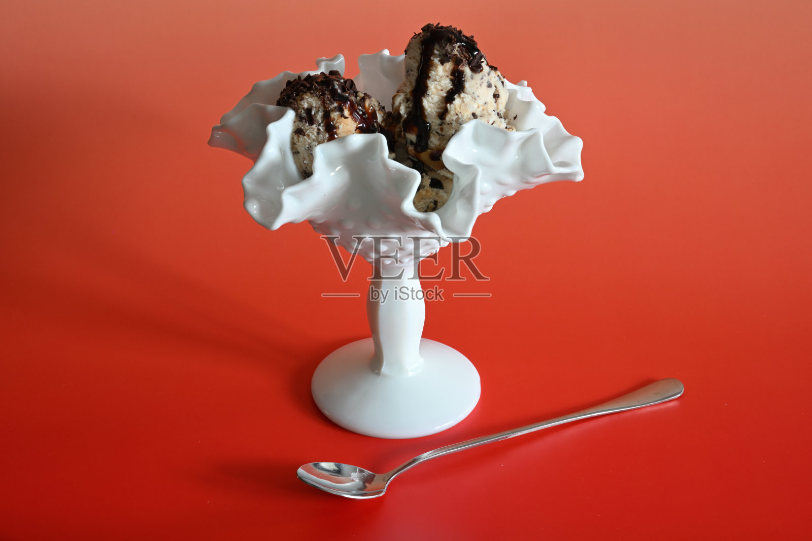 白色冰淇淋碗，内有三球冰淇淋，背景色彩缤纷照片摄影图片