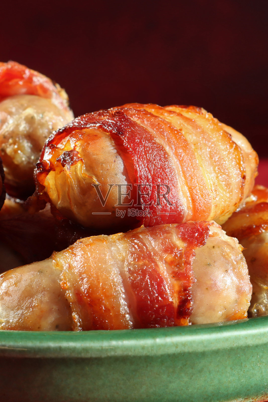 圣诞节日盘，配有酥脆的烤香肠（培根卷香肠），装饰有新鲜迷迭香和香草照片摄影图片