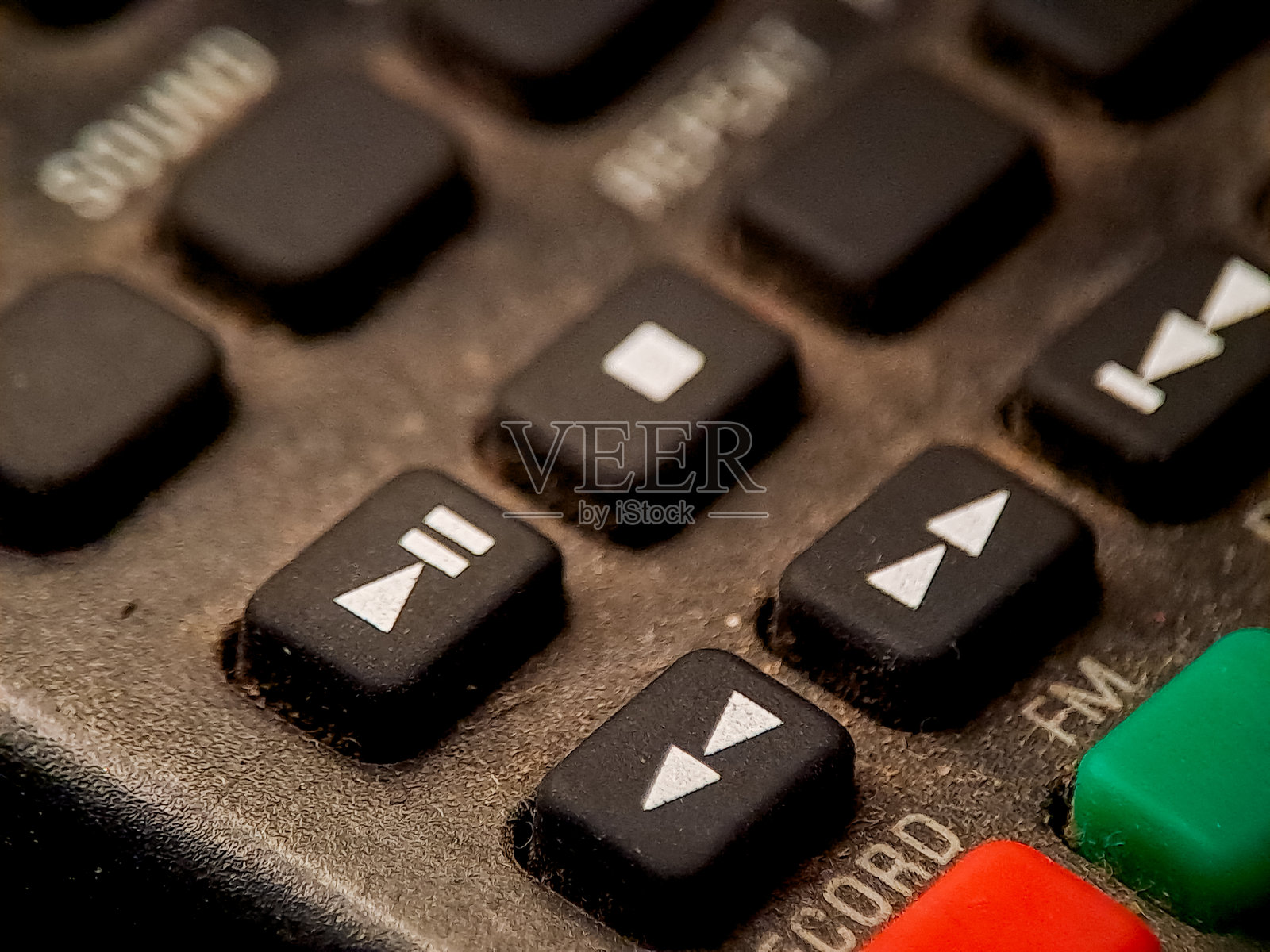 宏观图像显示老式电子设备上带有陈旧、纹理表面的按钮。照片摄影图片