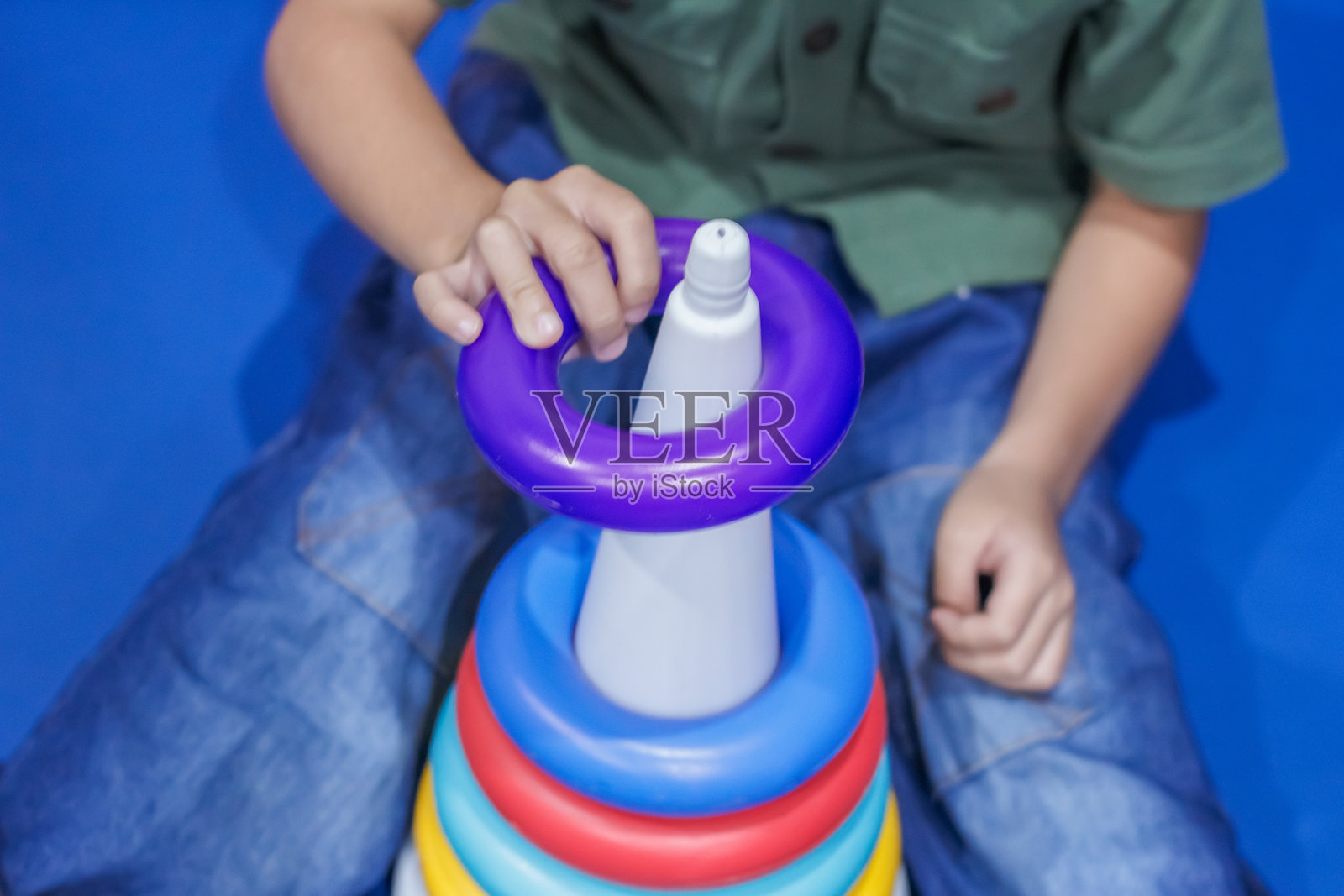 一个孩子在玩色彩鲜艳的叠叠乐玩具，有助于锻炼手眼协调能力和早期学习技能照片摄影图片