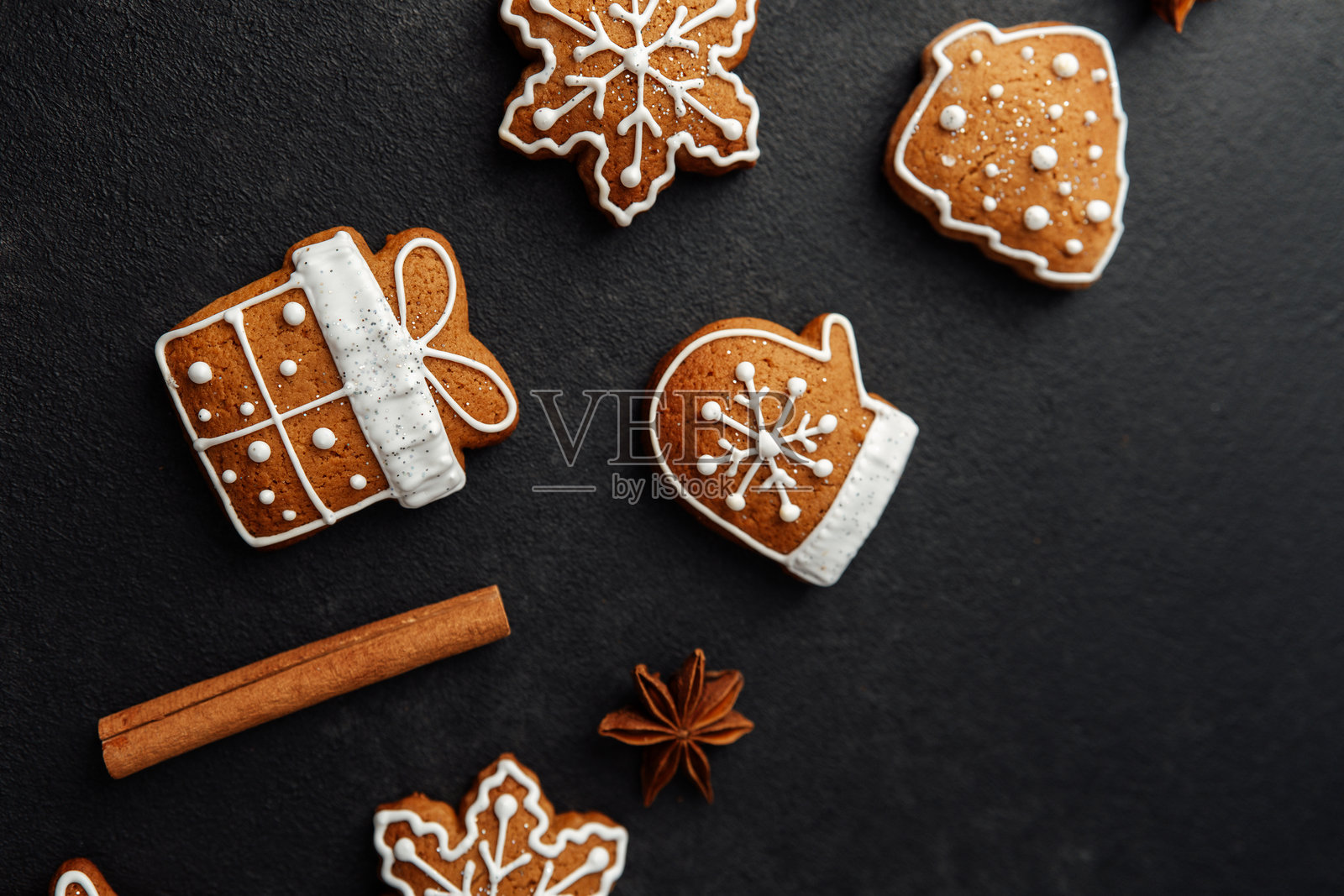 深色背景上装饰着糖霜和香料的圣诞姜饼照片摄影图片