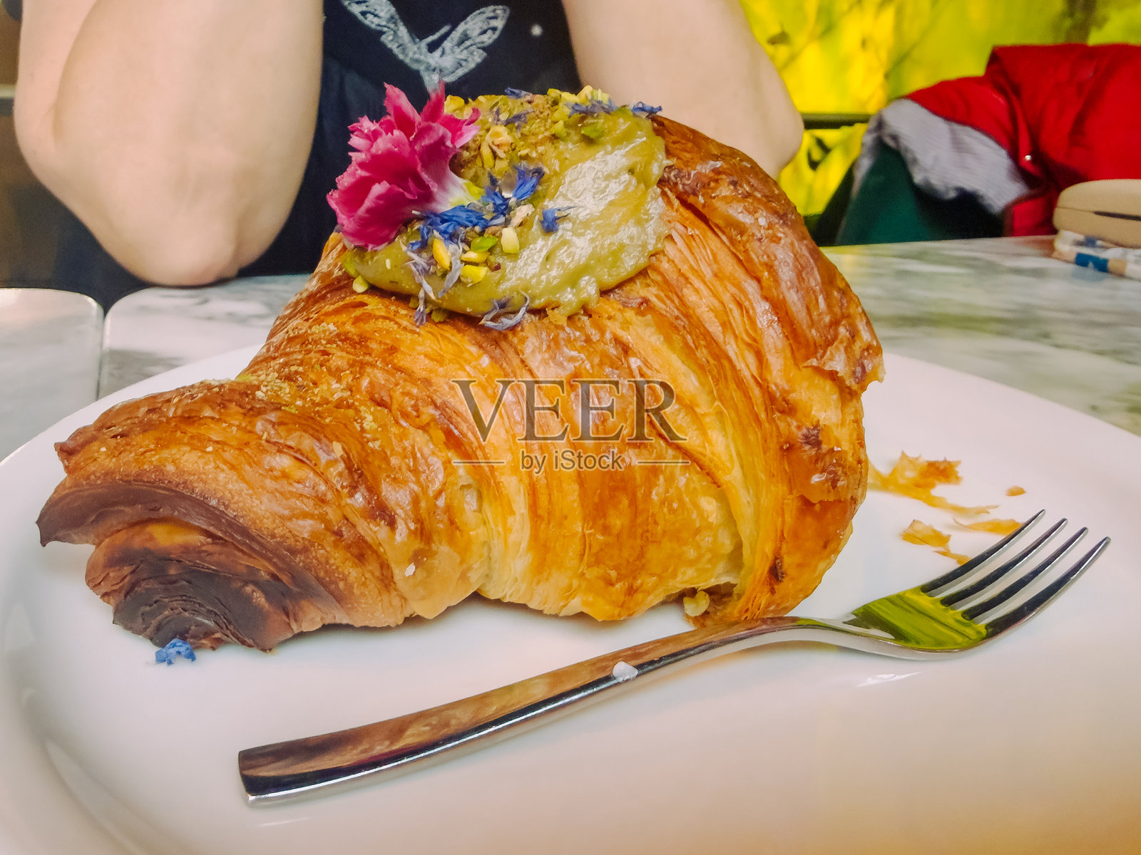 意大利可颂，夹有开心果奶油馅，美味的传统可颂甜点，象征着甜蜜的早餐和意大利烘焙文化照片摄影图片