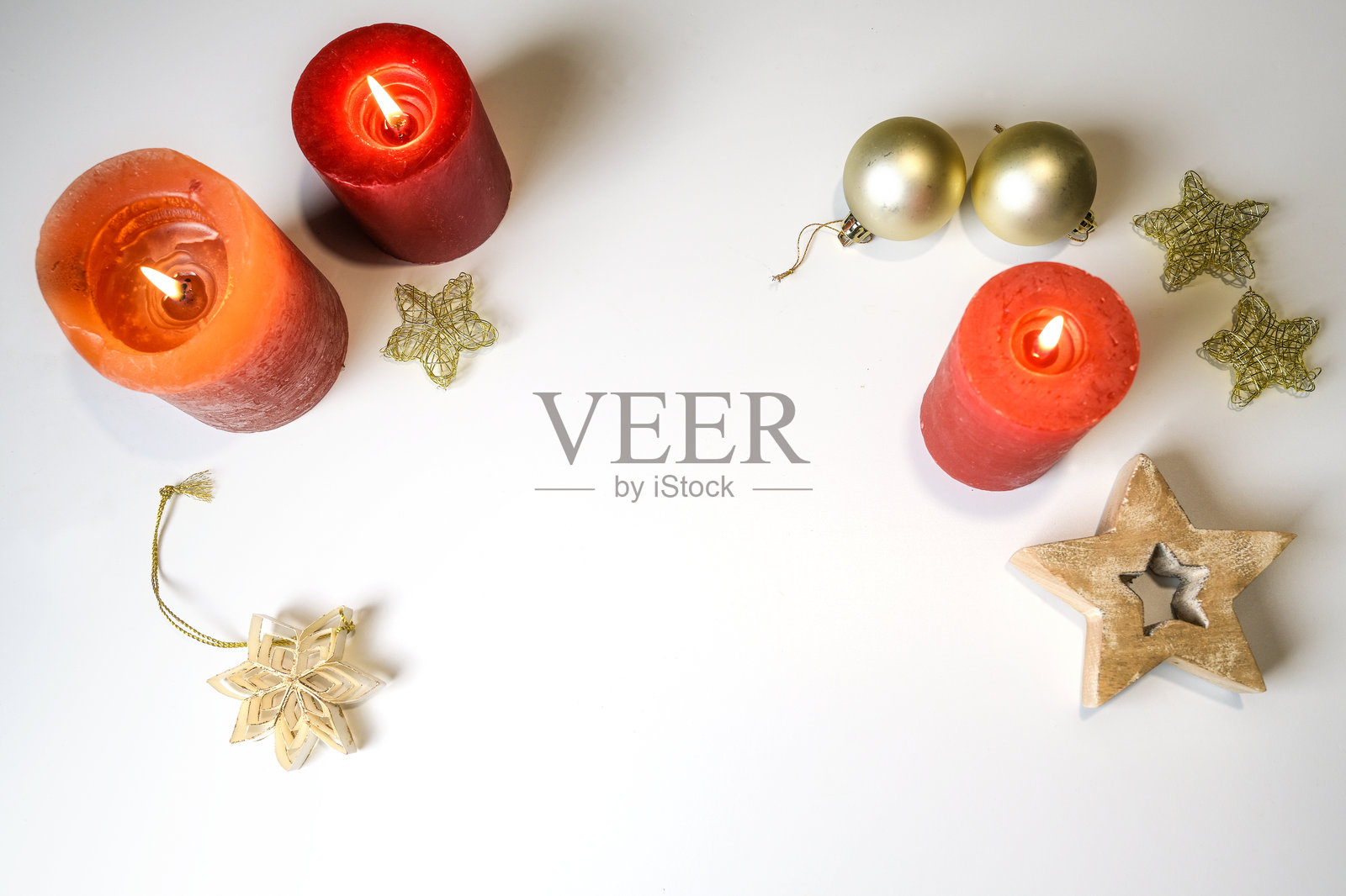 浅灰色背景上的红色蜡烛、圣诞彩球和星星装饰，中间留有空白供您添加文字，节日布置，俯视视角照片摄影图片