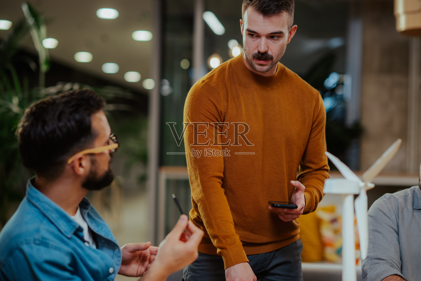 同事们在现代办公室协作进行可再生能源项目照片摄影图片