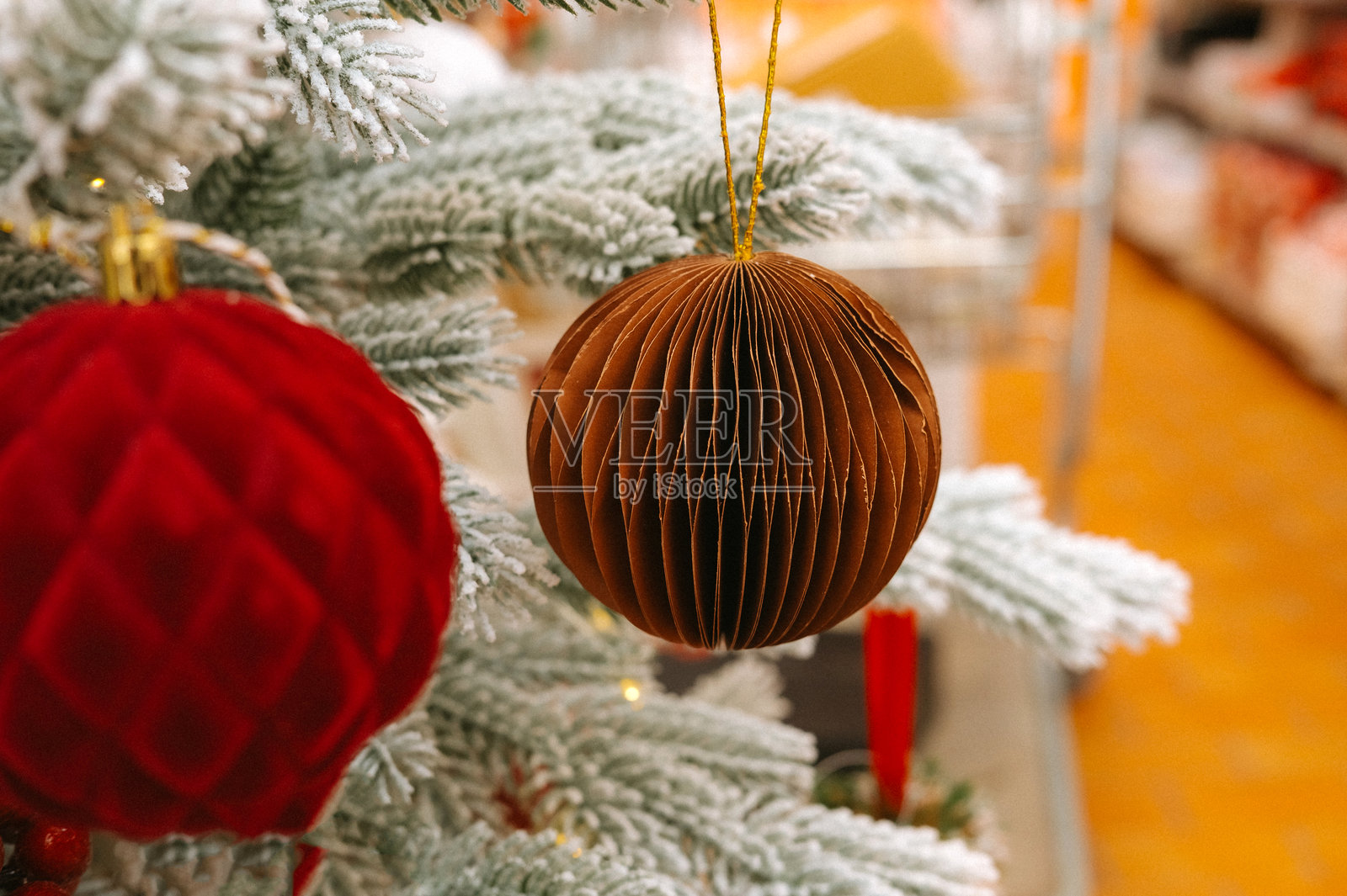 装饰着红色和棕色饰品以及雪景树枝的节日圣诞树照片摄影图片