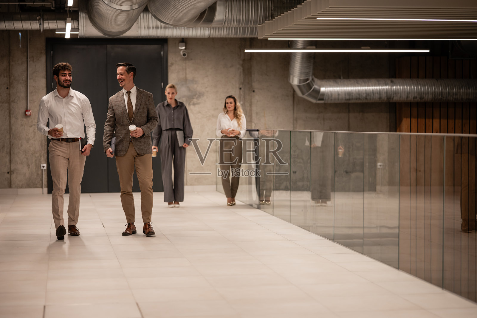 商务同事在现代办公室里边走边讨论照片摄影图片