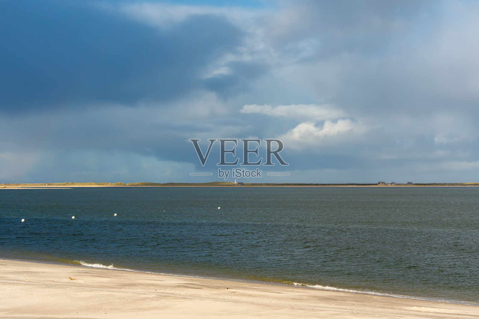 远方有灯塔和乌云的海景照片摄影图片