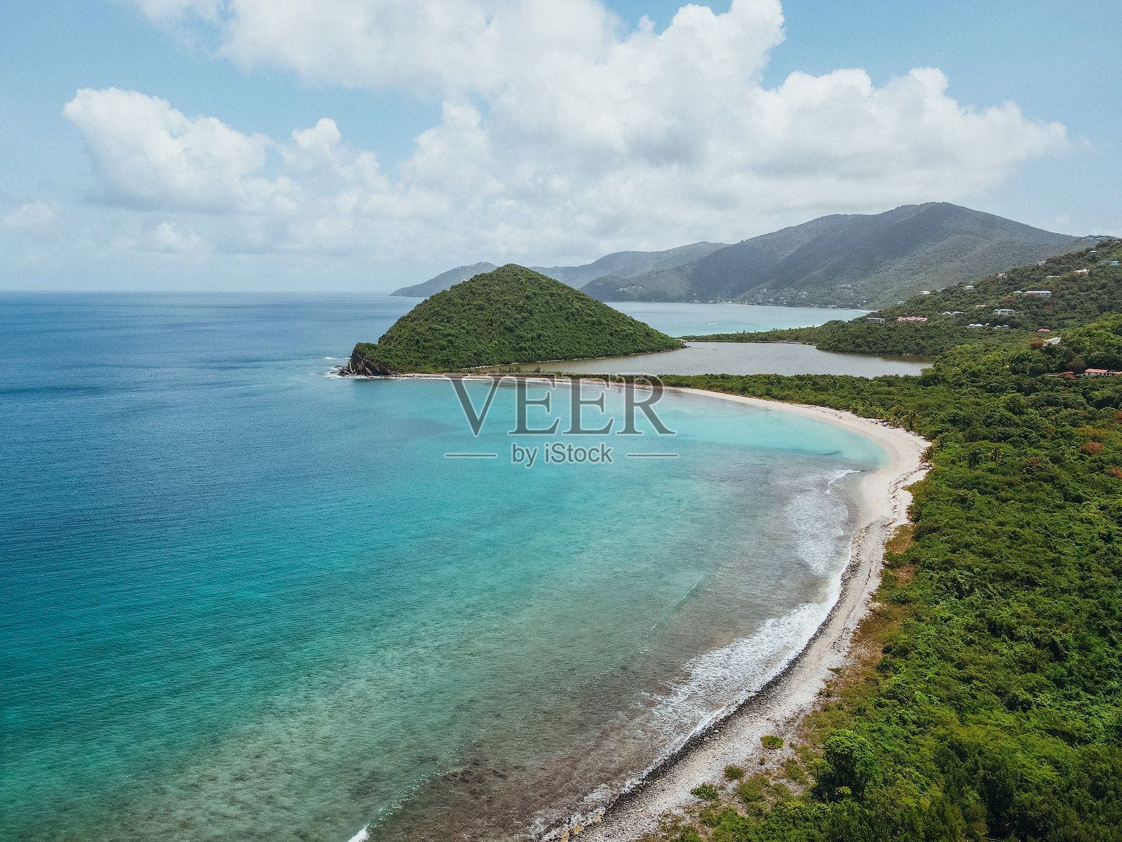 拥有清澈蓝色海水和山丘的热带海滩照片摄影图片