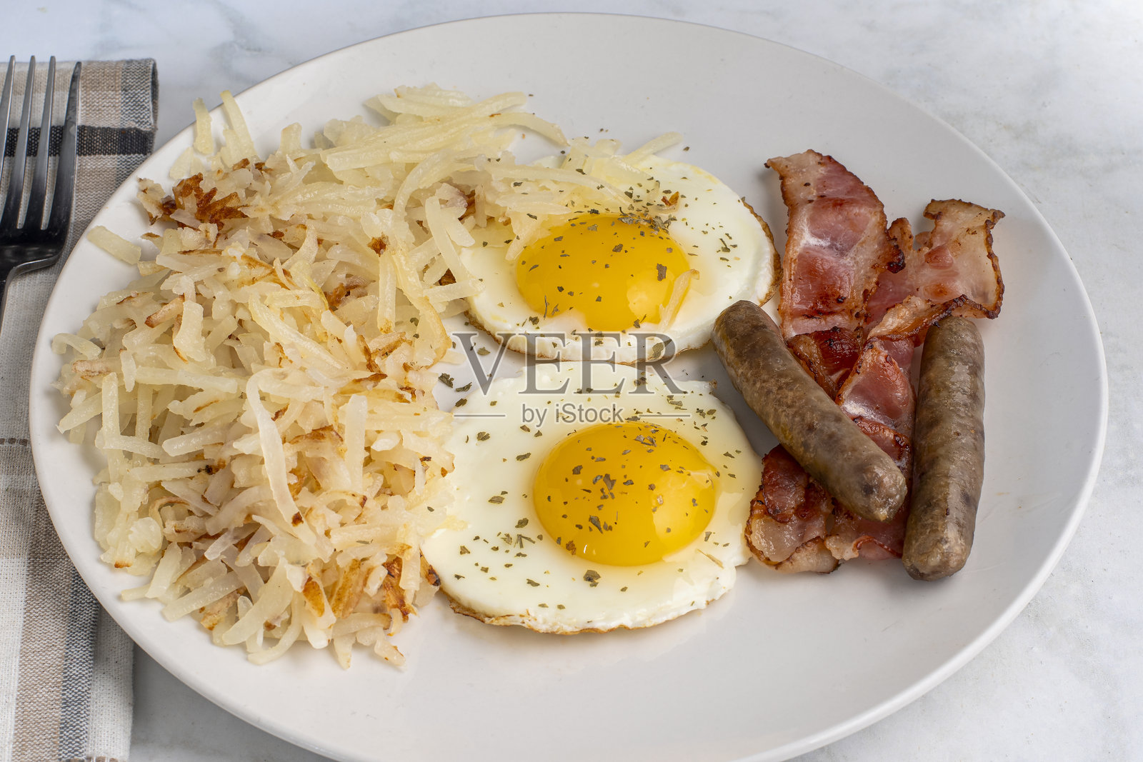 煎鸡蛋搭配早餐香肠和培根照片摄影图片