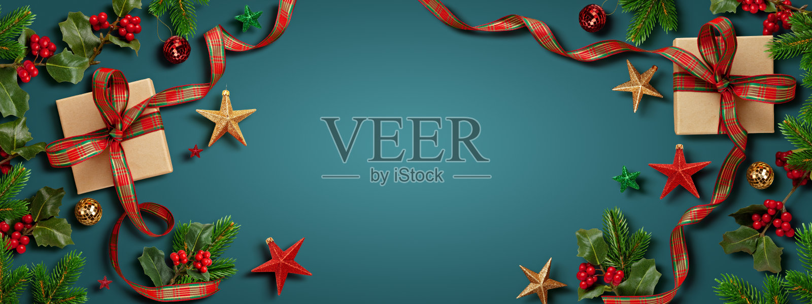 俯视视角，蓝底上的节日装饰框，包含包装好的礼物、装饰品和绿植，适合圣诞节或季节性祝福。照片摄影图片