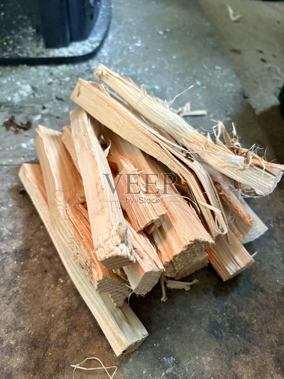 一叠整齐的干木柴，准备用于生火。这些细小的劈开木块展示了自然的纹理和质感，非常适合壁炉、露营或乡村家居取暖场景。照片摄影图片