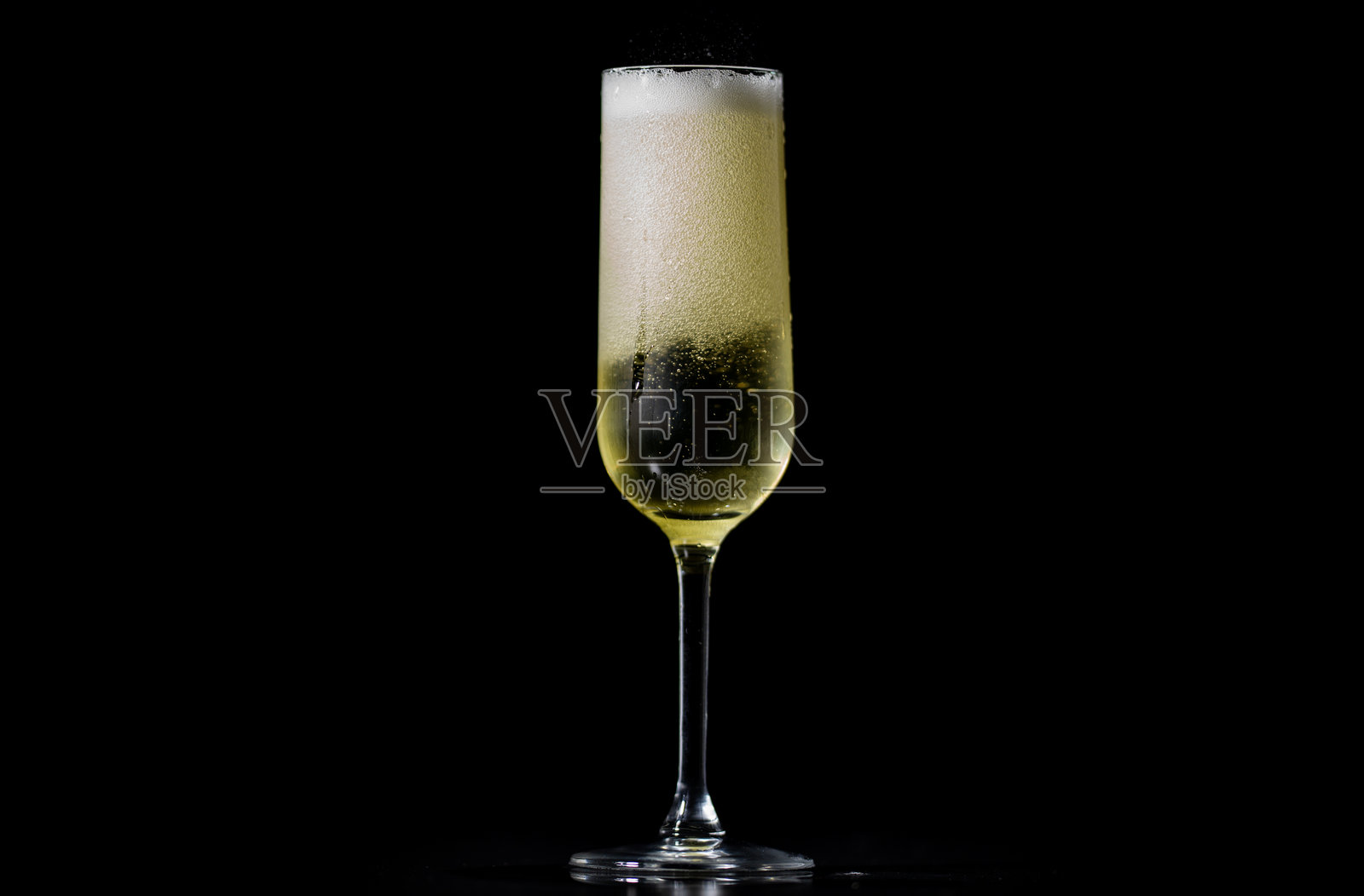 节日里，香槟酒被斟满，气泡升腾。闪耀的香槟杯中，气泡翻腾。酒杯里盛着冒着气泡的起泡酒。照片摄影图片