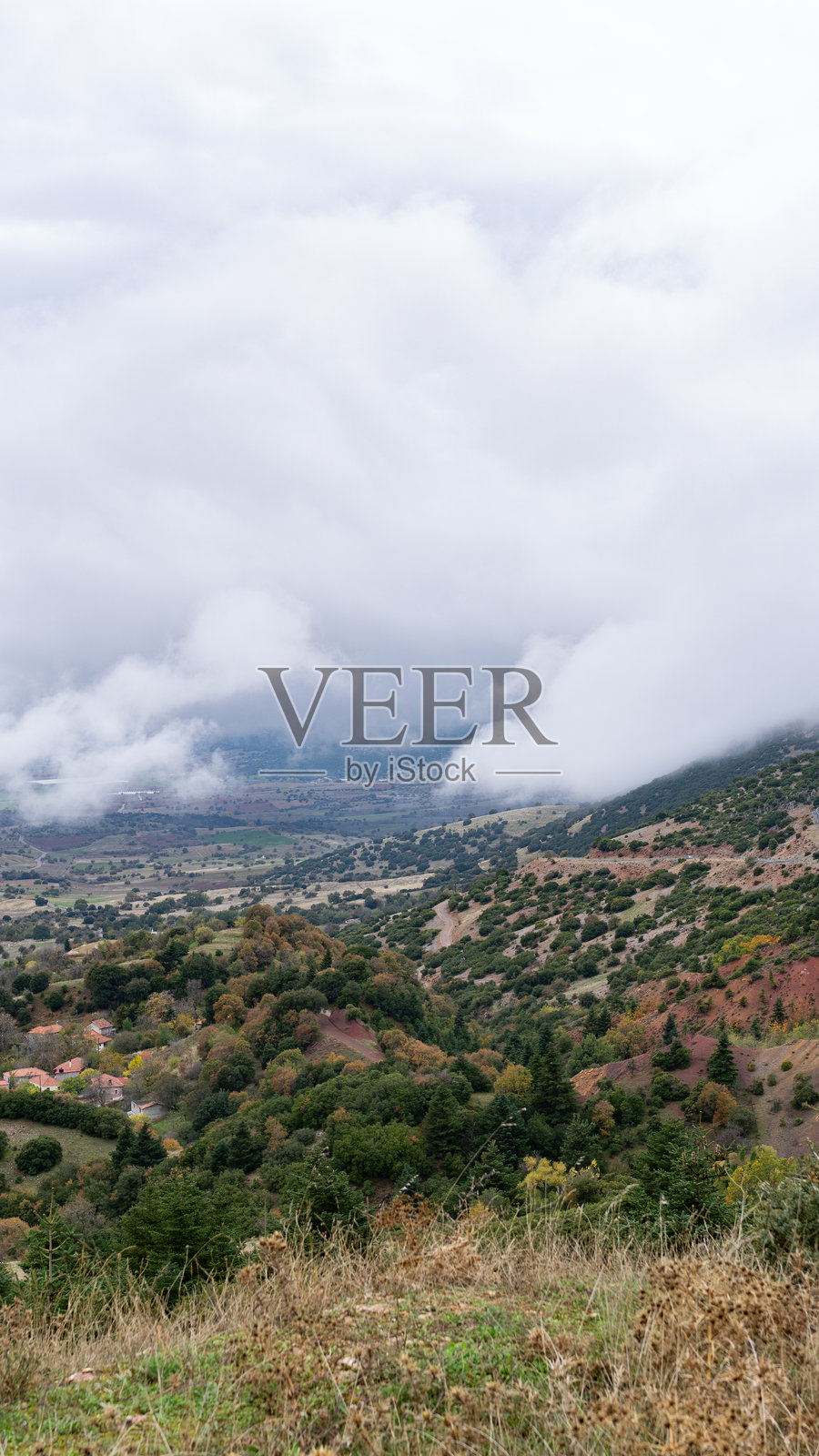 云雾缭绕的峰顶与道路的戏剧性山景照片摄影图片