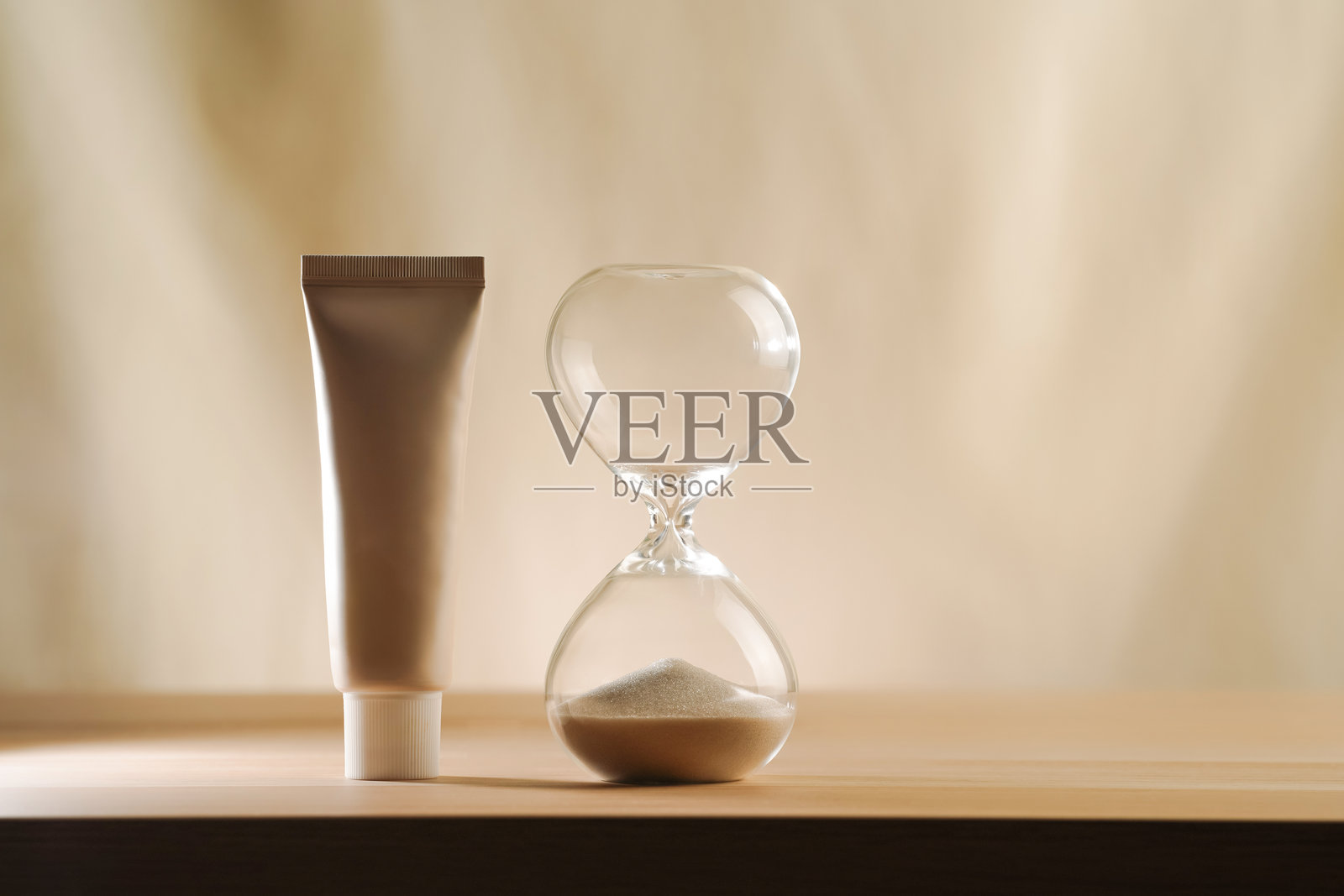 沙漏中的时间耗尽，奶油管已满照片摄影图片