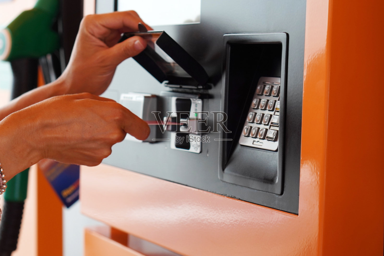 女士在加油站用信用卡支付油费照片摄影图片