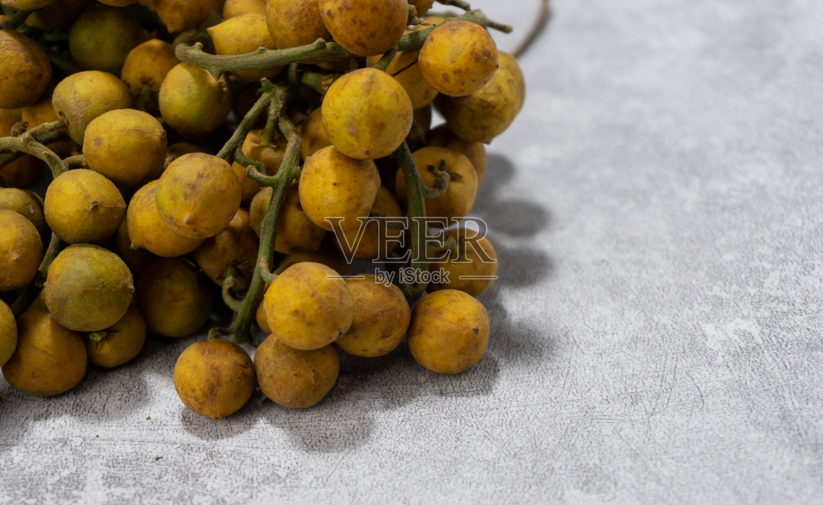 灰桌上的黄棕色皮肤的浆果照片摄影图片