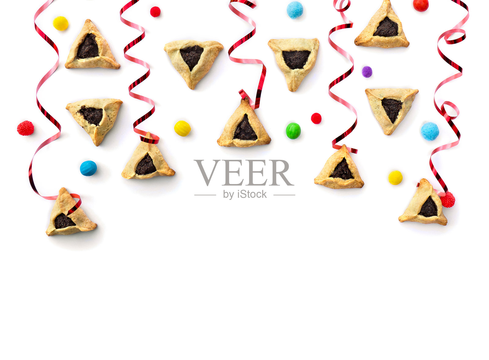 犹太逾越节的三角饼干（哈曼塔什或阿曼耳朵），彩色糖果和红色彩带，在白色背景上，留有文本空间。俯视，平面图。照片摄影图片