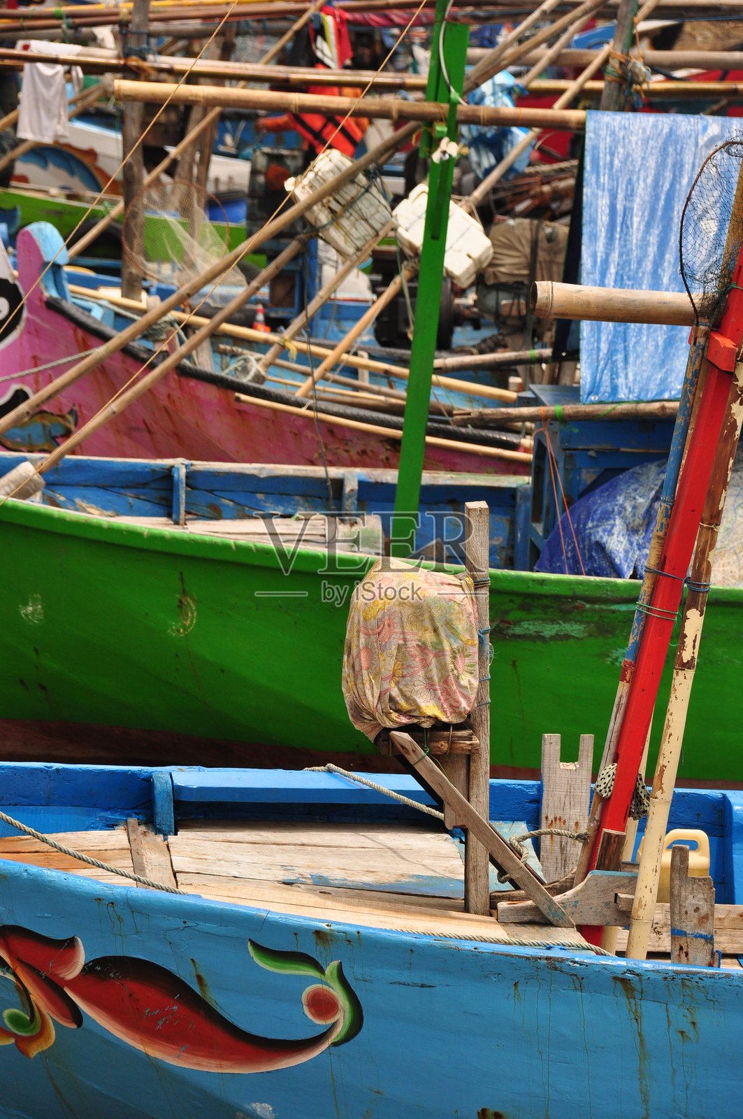 色彩鲜艳的渔船停靠在港口，为当天的渔获做准备，一派繁忙景象。照片摄影图片