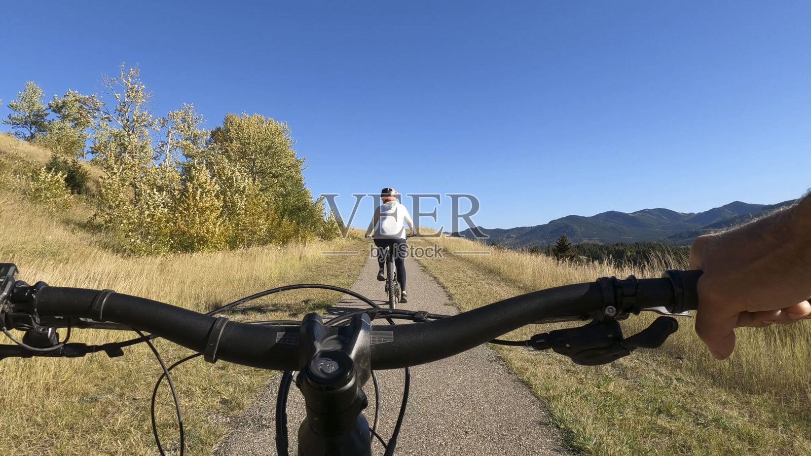 情侣骑行电动自行车在山间小路上，个人视角照片摄影图片