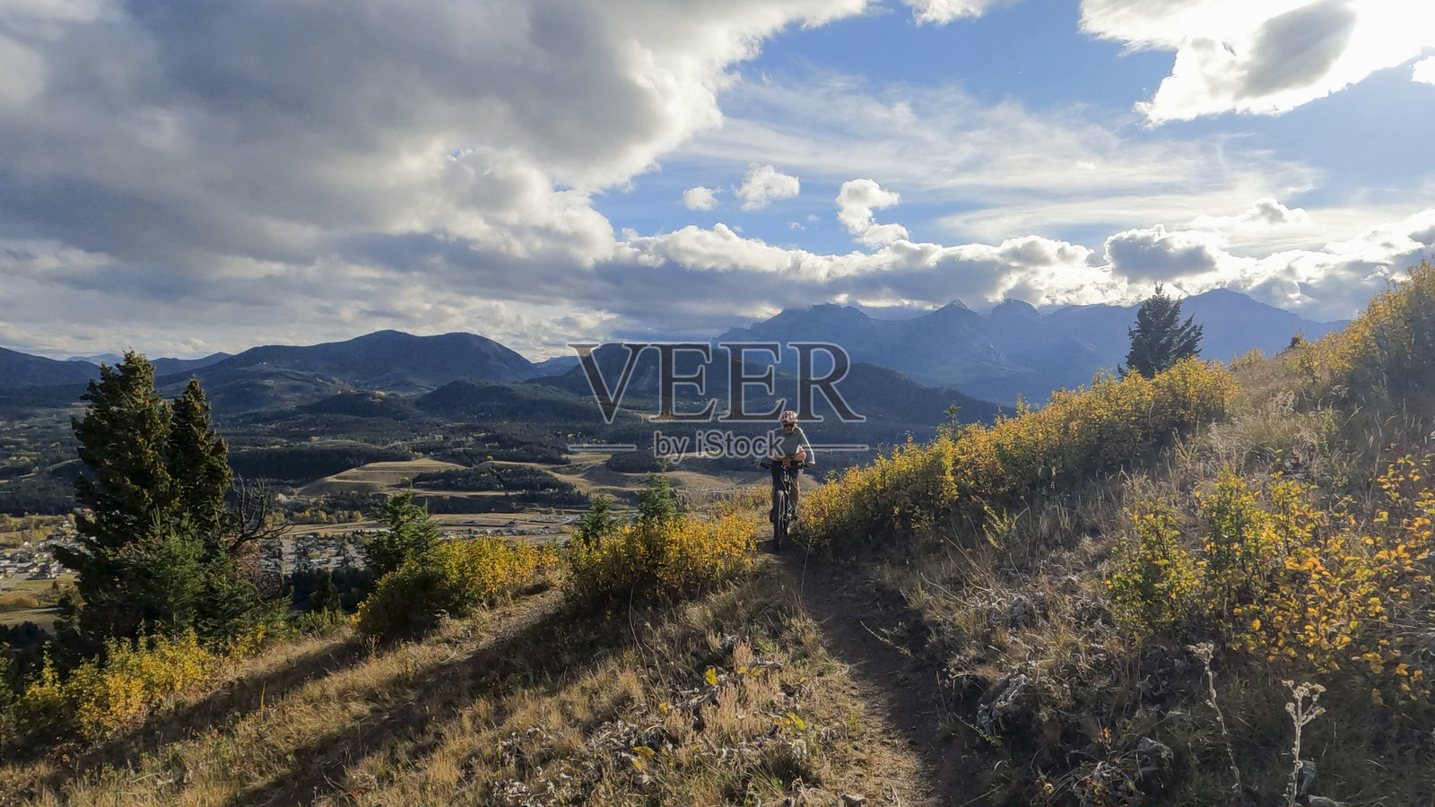 女子骑电动山地车在山间小径上照片摄影图片