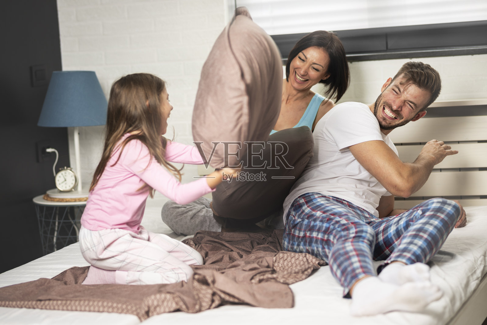 快乐的一家四口在玩枕头大战照片摄影图片