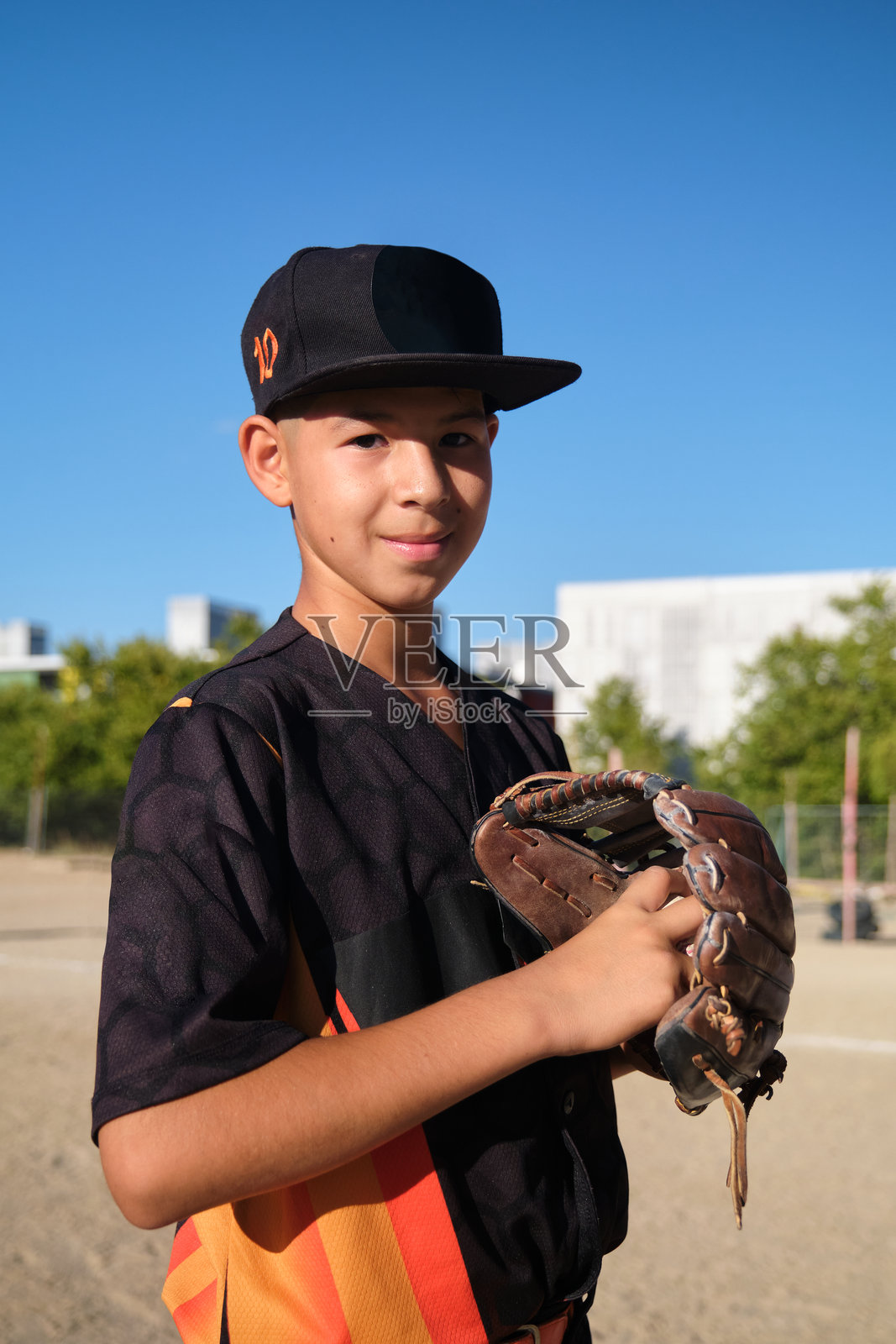 小男孩在球场上玩棒球，手持棒球手套照片摄影图片
