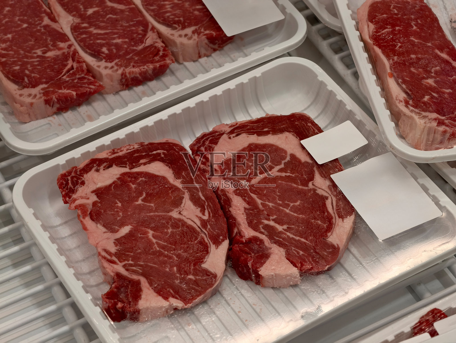 冷藏托盘中展示的新鲜包装牛肉牛排照片摄影图片