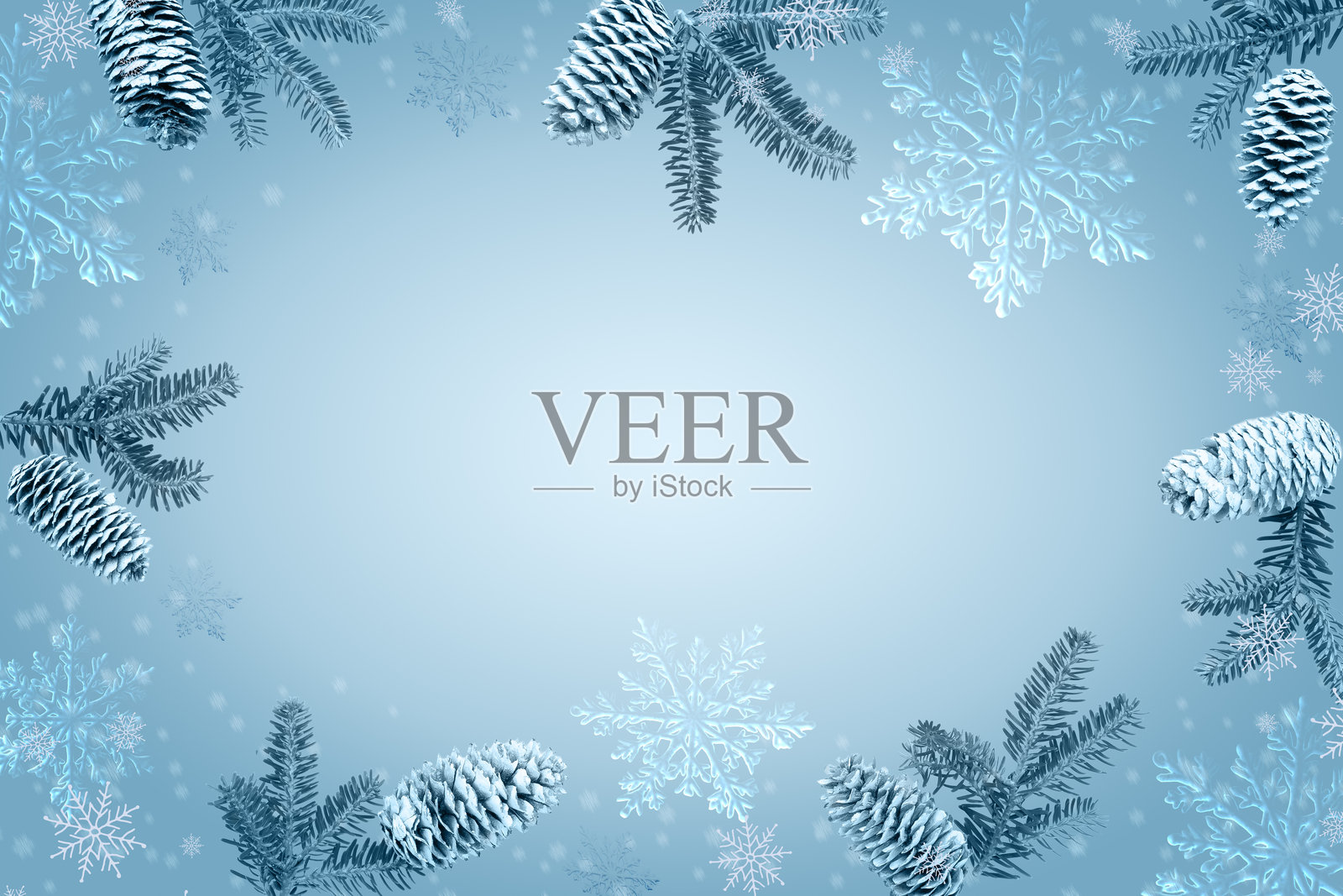 冰蓝色背景，边缘饰有雪花和松果，非常适合冬季节日主题和贺卡。冰霜松果边框照片摄影图片