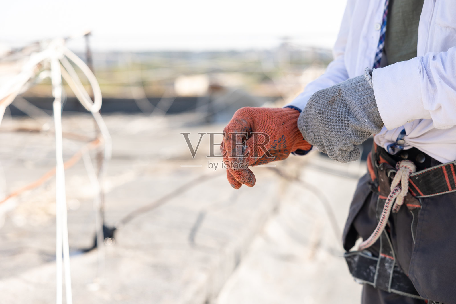 建筑工人正在戴防护手套。照片摄影图片