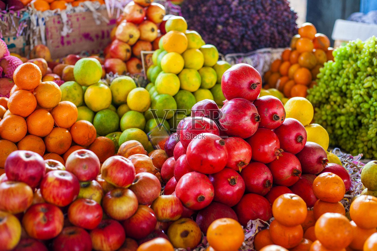 色彩鲜艳的水果：苹果、橙子、葡萄，在印度街头市场。照片摄影图片