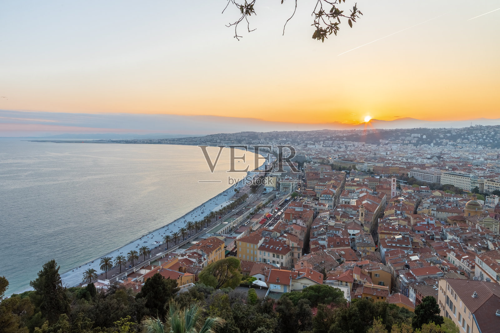 初春时分，从老城区城堡（Vieux）眺望，尼斯的海岸线上出现金色时段的日落美景，地中海宁静而辽阔。照片摄影图片