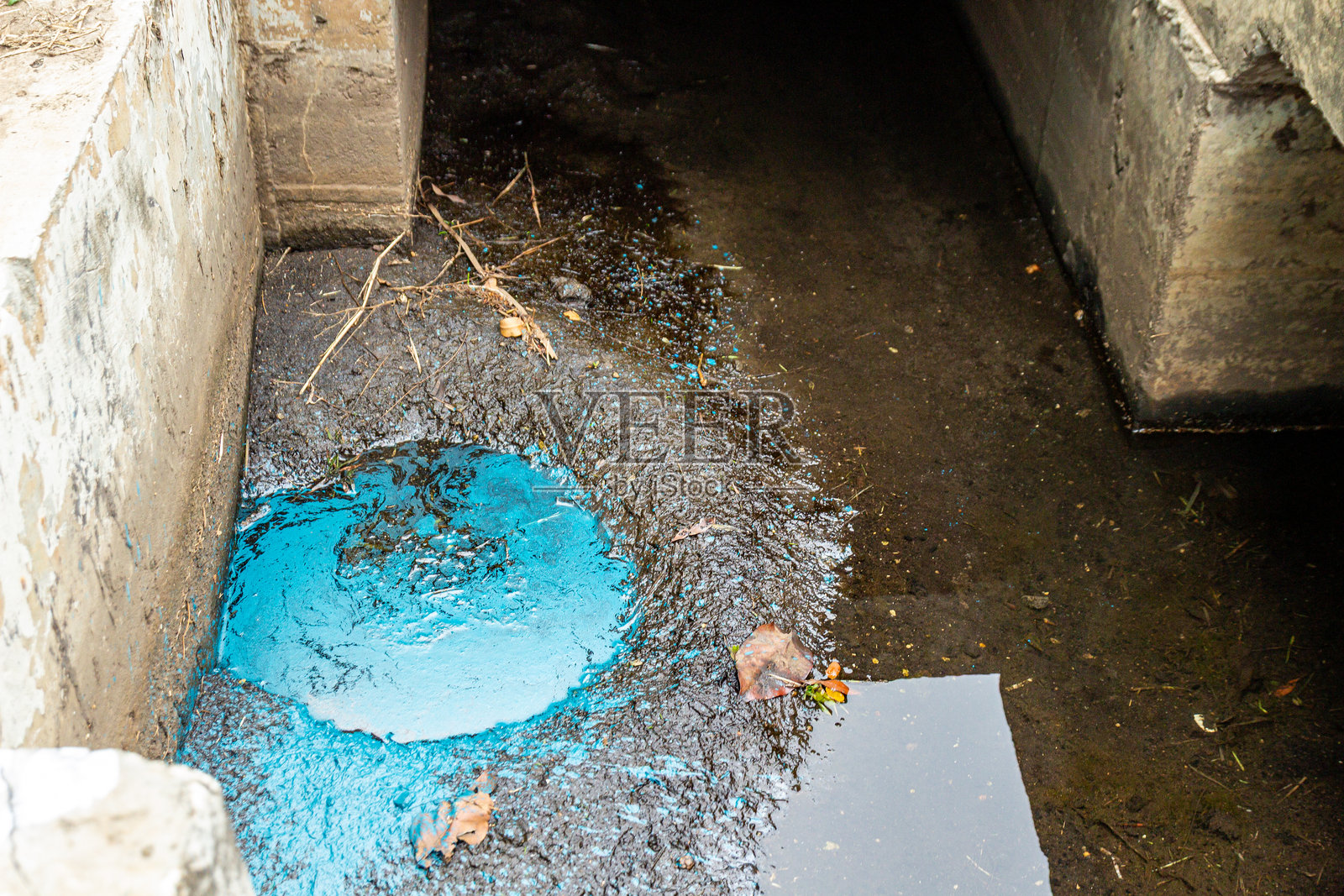 深邃的蓝色液体汇聚在混凝土池中，反射着光线，形成了鲜明的对比。照片摄影图片