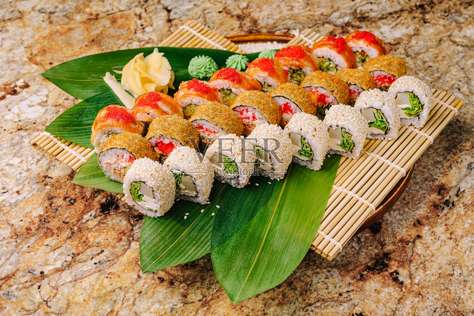 用竹席盛放的色彩缤纷的寿司拼盘，配以新鲜的装饰照片摄影图片