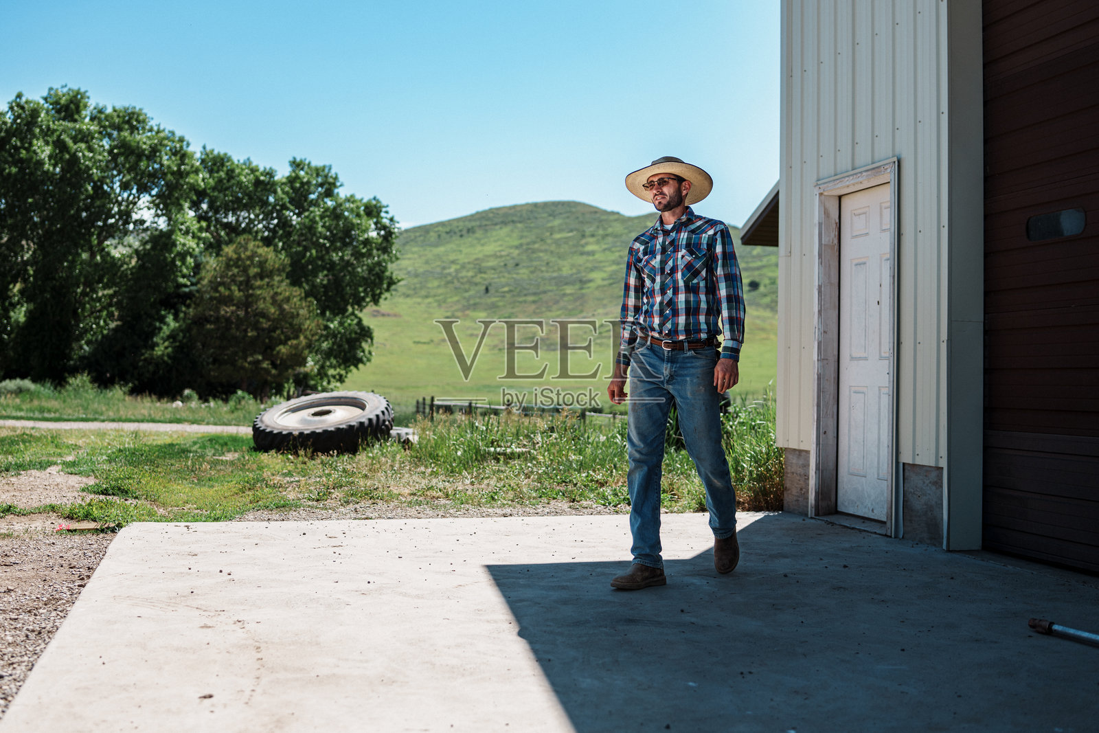 牧场主离开谷仓，前往牧场田地收割干草照片摄影图片
